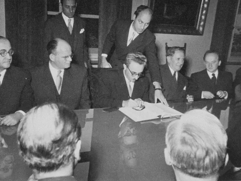 A still from Reckonings: Israeli Foreign Minister Moshe Sharett signs the Reparations Agreement between the German Federal Republic, the State of Israel, and the Conference on Jewish Material Claims.